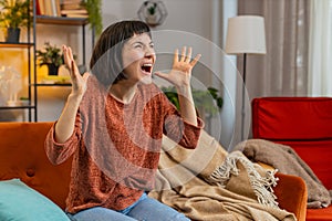 Sad woman feeling hopelessness loneliness nervous breakdown crying shouting while sitting on sofa