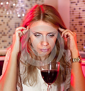 Sad woman with glass of red wine