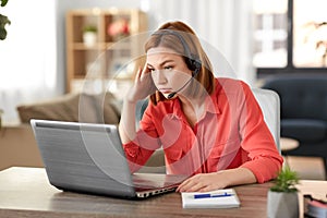 Sad woman with headset and laptop working at home