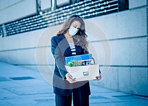 Sad woman holding box outside office feeling hopeless after being fired. Coronavirus job cuts crisis