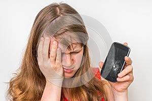 Sad woman is holding mobile phone with broken screen