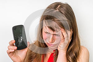 Sad woman is holding mobile phone with broken screen