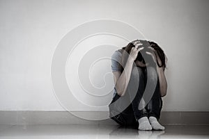 Sad woman hug her knee and cry. Sad woman sitting alone in a empty room