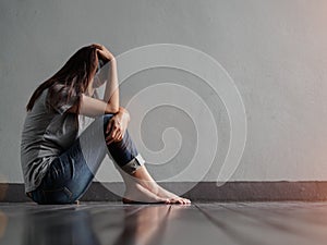 Sad woman hug her knee and cry while sitting alone