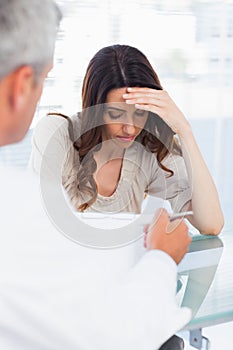 Sad woman listening to her docter talking about a illness