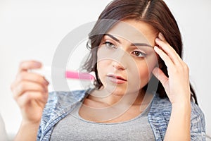 Sad woman looking at home pregnancy test