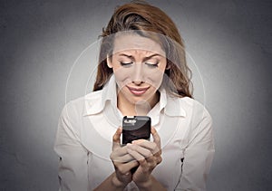 Sad woman looking at mobile phone