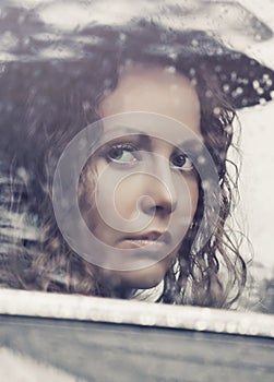 Sad woman looking out window driving a car