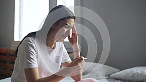 Sad woman looking on pregnancy test unexpected cries