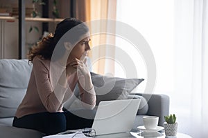 Sad woman looks aside saddened with bad news online