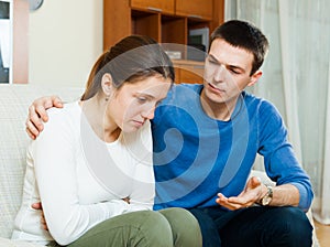 Sad woman, man consoling her photo