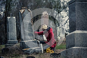 Sad Woman in Mourning Touching a loved one's Gravestone