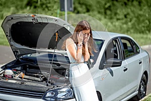 Sad woman near the broken car