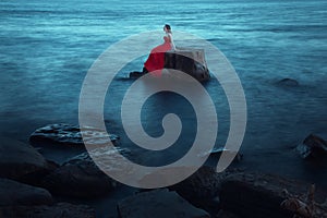 A sad woman near the sea in evening