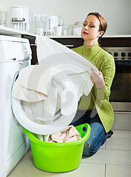 Sad woman near washing machine