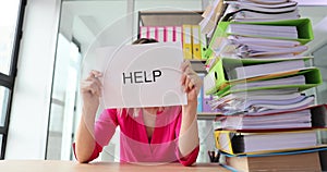 Sad woman in office with tax burden and paper files and asking for help