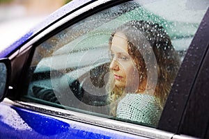 Smutný žena v auto v déšť 
