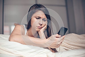 Sad woman reading message on the phone