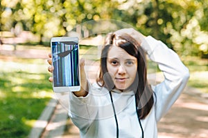sad woman showing cracked mobile screen after drop