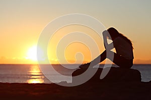 Sad woman silhouette worried on the beach
