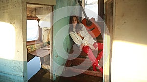 Sad woman sits with guitar inside of old ship.