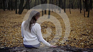 Sad woman sitting in autumn park remembering deceased husband, loss of loved one