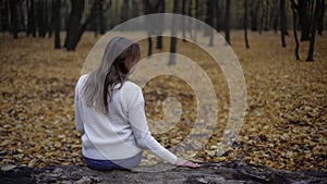 Sad woman sitting in autumn park remembering deceased husband, loss of loved one photo