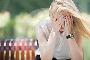 Sad woman sitting on bench outdoors