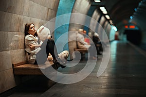 Sad woman sitting on a bench in the subway.