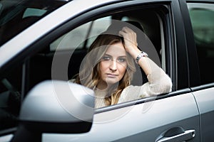 Sad woman sitting in car on a driver`s seat