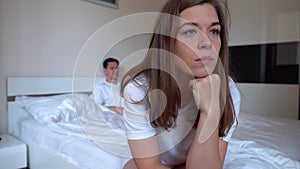 Sad woman sitting on the edge of the bed