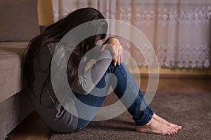 Sad woman sitting on the floor