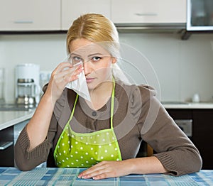 Sad woman sitting at kitchen