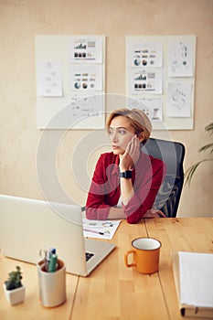 Sad Woman Sitting Office. Bored Businesswoman Looking Away At Her Workplace