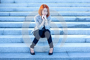 Sad woman sitting outside and waiting for someone