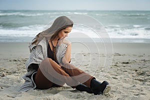 Sad woman sitting on a sea beach