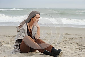 Sad woman sitting on a sea beach