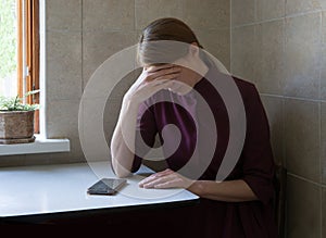 Sad woman sitting at the table