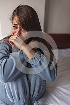 Sad woman sobbing in bed