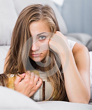 Sad woman on sofa with pillow