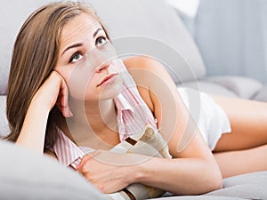 Sad woman on sofa with pillow