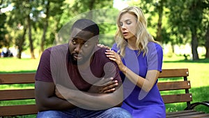 Sad woman sorrying boyfriend for cheating, sitting on bench in park, break-up