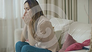 Sad woman talking phone on home sofa. Depressed customer using mobile phone