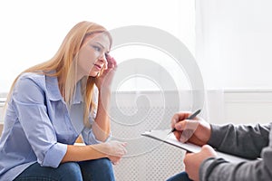 Sad woman talking to her psychotherapist at personal meeting