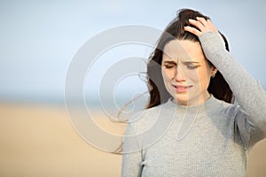 Sad woman walking alone on the beach