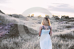 Sad woman walking alone at meadows,loneliness