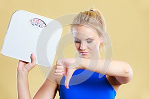 Sad woman with weight gain thumb down sign