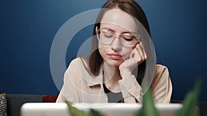 Sad woman working laptop computer at the home. An unhappy caucasian woman uses laptop at home. Worried girl stress at