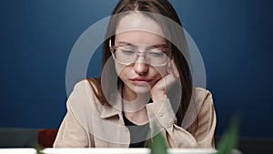 Sad woman working laptop computer at the home. An unhappy caucasian woman uses laptop at home. Worried girl stress at