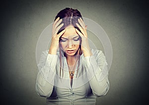 Sad woman with worried stressed face expression looking down